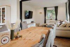 a living room with a couch and a table at Traumfabrik Eifel mit Sauna & Whirlpool in Monschau