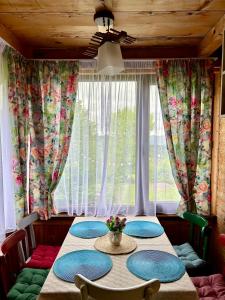 ein Esszimmer mit einem Tisch mit Stühlen und einem Fenster in der Unterkunft Cottage Racha Rhymes in Ambrolauri