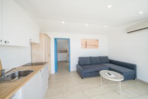 a living room with a blue couch and a kitchen at Yoga House Kaş in Kaş