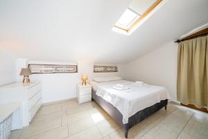 a white bedroom with a bed and a window at Yoga House Kaş in Kaş