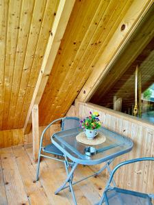 una mesa y sillas en un porche con techos de madera en Cottage Racha Rhymes, en Ambrolauri