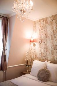 een slaapkamer met een kroonluchter en een bed met een kussen bij La Maison Gobert Paris Hotel Particulier in Parijs