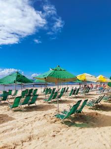 a group of lawn chairs and umbrellas on a beach at Sun Smart Hotel in Recife