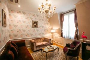 La Maison Gobert Paris Hotel Particulier في باريس: غرفة معيشة بها أريكة وكراسي وثريا