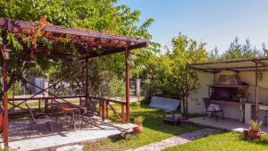 a backyard with a gazebo and a grill at Villa Sotiria in Néa Thésis