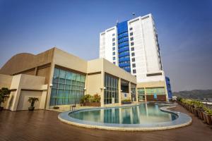 a building with a swimming pool in front of a building at Mega Hotel in Miri