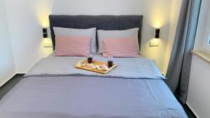 een bed met twee glazen en een dienblad met eten erop bij Apartments Cintya in Poreč