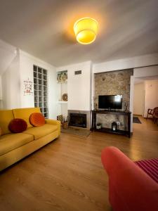 a living room with a yellow couch and a tv at Casa da Fonte Grande - By Cabralina Apartments in Belmonte