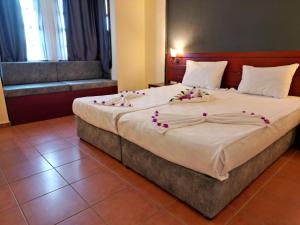 Postel nebo postele na pokoji v ubytování LEMAS SUITE HOTEL