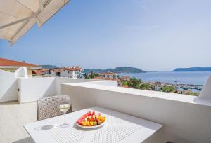 a table with a bowl of fruit and a glass of wine at Yoga House Kaş in Kaş