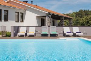 uma piscina com cadeiras e uma casa em Estrela de Montesinho em Bragança