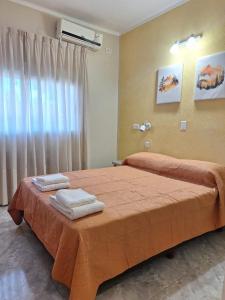 a bedroom with a bed with two towels on it at Hotel Mon Chéri in Villa Carlos Paz +44 photos