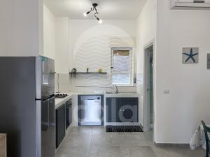 a kitchen with a sink and a refrigerator at Roma n 3 in Torre Lapillo