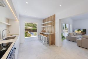 a kitchen and living room with a couch and a table at Villa Bonjour in El Port