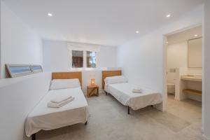 a room with two beds and a bathroom with a sink at Villa Bonjour in El Port +29 photos