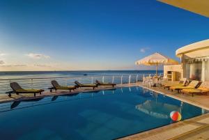 - une piscine avec des chaises et une vue sur l'océan dans l'établissement Villa Watersedge, à Marsaskala