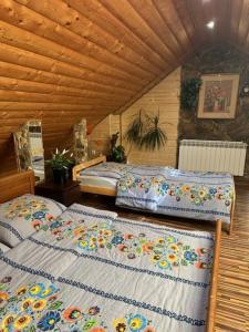 1 dormitorio con 2 camas en una habitación de madera en Domki letniskowe pod Brzozami Stella, en Polańczyk