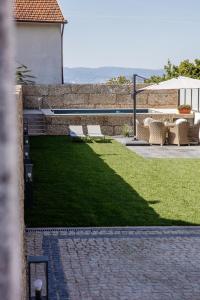 a garden with a bench and a table and chairs at Casa Gondiga in Roriz