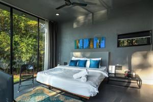 ナーシクにあるStayVista's Villa Meer - Lakeview Villa with Spacious Pool & Terrace for Stargazingの青い枕が付いた大きなベッドのある寝室