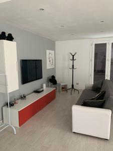 ein Wohnzimmer mit einem Sofa und einem Flachbild-TV in der Unterkunft L olivo in Lucca