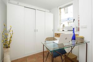 ein Büro mit einem Glasschreibtisch und einem Laptop in der Unterkunft L'Hostalet de Cadaques in Cadaqués