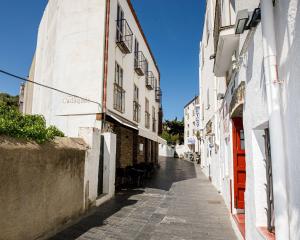 un callejón en un casco antiguo con edificios blancos en L'Hostalet de Cadaques, en Cadaqués