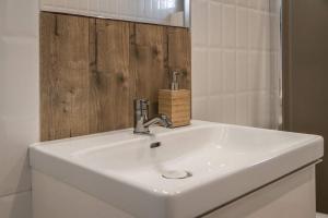 a white sink in a bathroom with a mirror at Leśne Apartamenty in Bobolice +48 photos