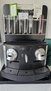 una macchina per caffè espresso con tazze su uno scaffale di Hotel Puntazo II a Mojácar