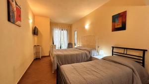um quarto de hotel com três camas e uma janela em Agriturismo Azzurra Biricchina em Riva Ligure