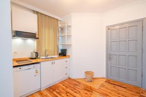 a kitchen with white cabinets and a wooden floor at Yoga House Kaş in Kaş