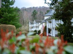 ein großes weißes Haus mit einem Hof mit roten Blumen in der Unterkunft Dünenpark Binz - Komfortplus Ferienwohnung mit 1 Schlafzimmer und Terrasse im Erdgeschoss 128 in Binz