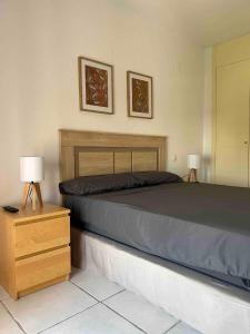 a bedroom with a bed and a nightstand with two lamps at Ático junto al Mar,Acceso directo a la playa,Jardines de Nuevo Vera,WIFI in Vera