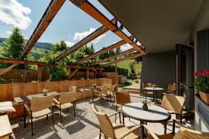 a patio at a restaurant with tables and chairs at Erzherzog Johann Alpin Style Hotel - Adults Only in Schladming