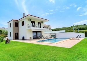 a villa with a swimming pool and a house at Villas Hanioti in Hanioti