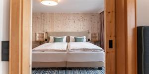 - une chambre dotée d'un grand lit avec des draps blancs et des oreillers verts dans l'établissement Erzherzog Johann Alpin Style Hotel - Adults Only, à Schladming 61 autres photos