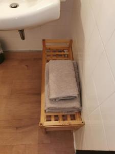 einen Stapel Handtücher auf einem Regal unter einem Waschbecken in der Unterkunft Terrassenwohnung mit toller Aussicht & zentrumsnah in Hornberg