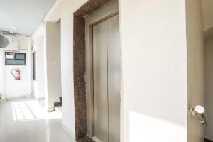 un pasillo con paredes blancas y una puerta de cristal en FabHotel Convivial Sky en Raipur