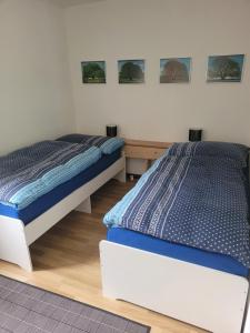 - 2 lits jumeaux dans une chambre avec des photos sur le mur dans l'établissement aschis Lodge 2, à Soubey