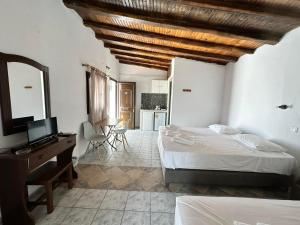 1 dormitorio con cama y escritorio con espejo en Villa Nikos Koukounaries en Koukounaries