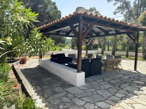 a wooden pergola with a couch on a patio at Villa Nikos Koukounaries in Koukounaries