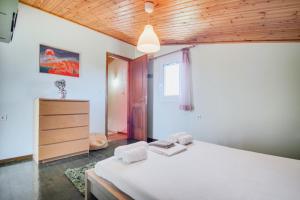 a bedroom with a white bed and a wooden ceiling at Villa Sotiria in Néa Thésis