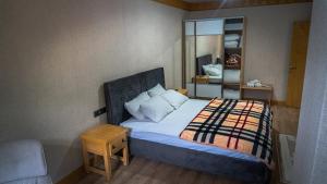 a small bedroom with a bed and a mirror at Ayder Elif Apart Daire in Ayder Yaylasi