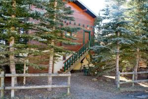 une maison avec un escalier à côté de quelques arbres dans l'établissement Chalet Bippo Pyrénées 2000 WiFi fibre, à Bolquère-Pyrénées 2000