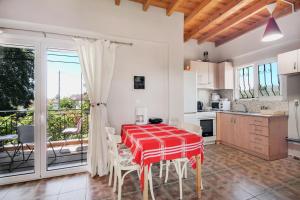 a kitchen and dining room with a red table and chairs at Villa Sotiria in Néa Thésis +35 photos