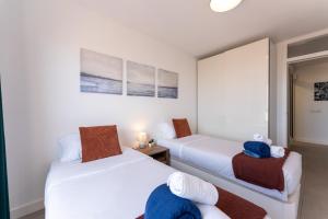 ein Schlafzimmer mit zwei Betten und einem Spiegel in der Unterkunft Callao sunset apartment, sea view and pool in Callao Salvaje + 59 Fotos