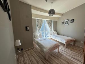 a bedroom with two beds and a large window at 2 Bedroom & 3 Bath Apartment in Dubai Marina - walking distance to JBR!" in Dubai