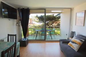 salon z kanapą i przesuwnymi szklanymi drzwiami w obiekcie Capbreton - CERS - Plage - Famille - Wifi w mieście Capbreton