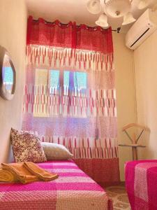 a bedroom with a bed with a colorful curtain at Casa Tavano in Avola