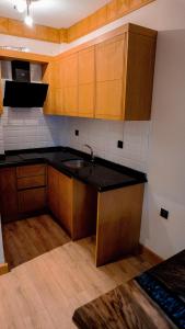 a kitchen with wooden cabinets and a black counter top at Ayder Elif Apart Daire in Ayder Yaylasi +43 photos