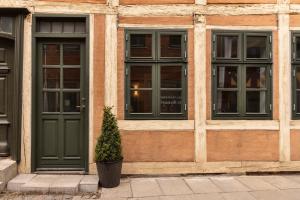 a building with a green door and a potted plant at Hotel Hamlet in Helsingør